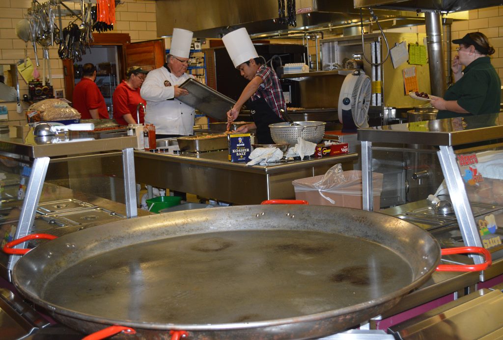 THE KITCHEN AT Mountain Lake Public School’s cafeteria is usually a beehive of activity as each day’s noon meal prep leads into the onslaught of hungry students. On Thursday, October 30, there was more action as Taher’s Corporate Chef Brian, at center left, was in the house to prepare the main dish – paella. Assisting him was Mountain Lake Public School senior Louis Louangthilath, center right. Staff bustling about include, Heidi Bergling, back left and Carol Kipfer, back right, as well as far right, Food Service Manager Tammy Wolle.