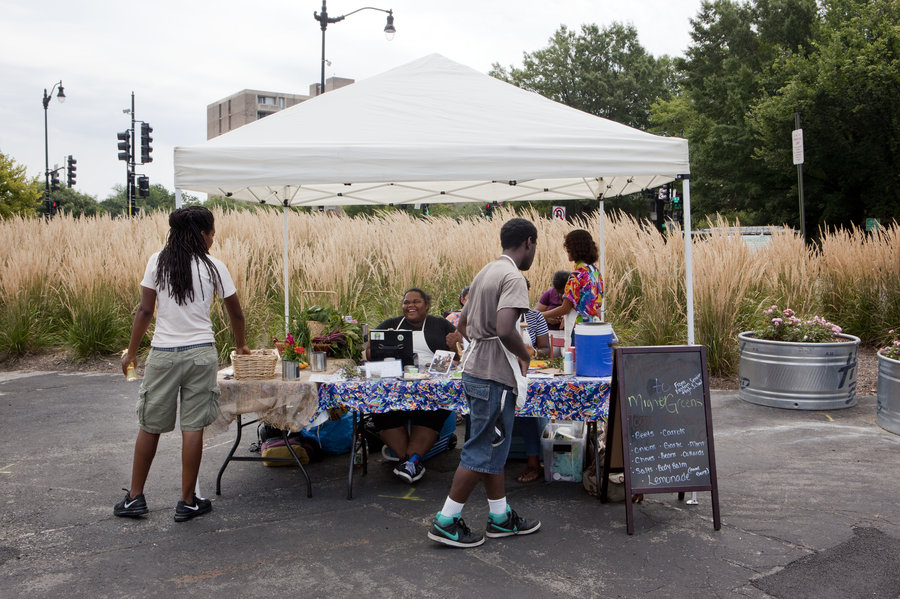 Students from Eastern Senior High School in Washington, D.C., sell vegetables, soaps and salts at the Aya farmers market on July 25. Lydia Thompson/NPR
